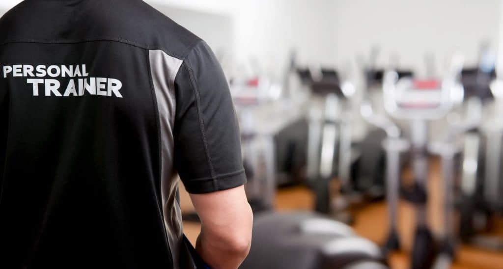 Personal trainer in the gym working with clients - Pros And Cons Of Being A Personal Trainer