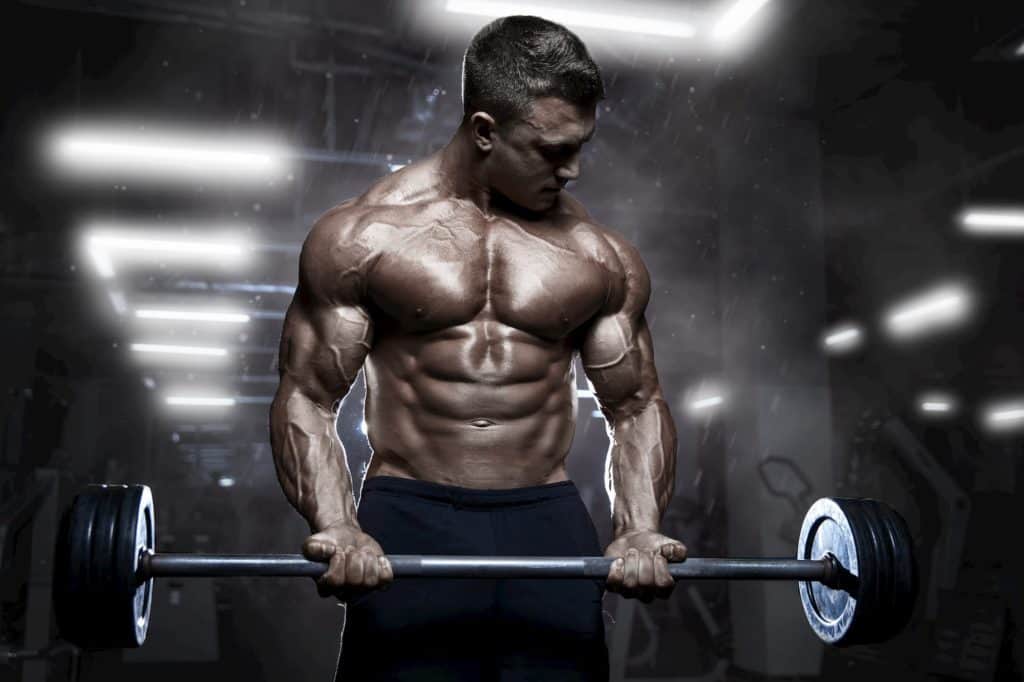 athletic muscular bodybuilder workout with barbell - post on how long does a pump last