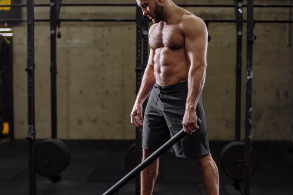 Man performing a hammer full body workout on the tire - Full Body Workout Every Other Day