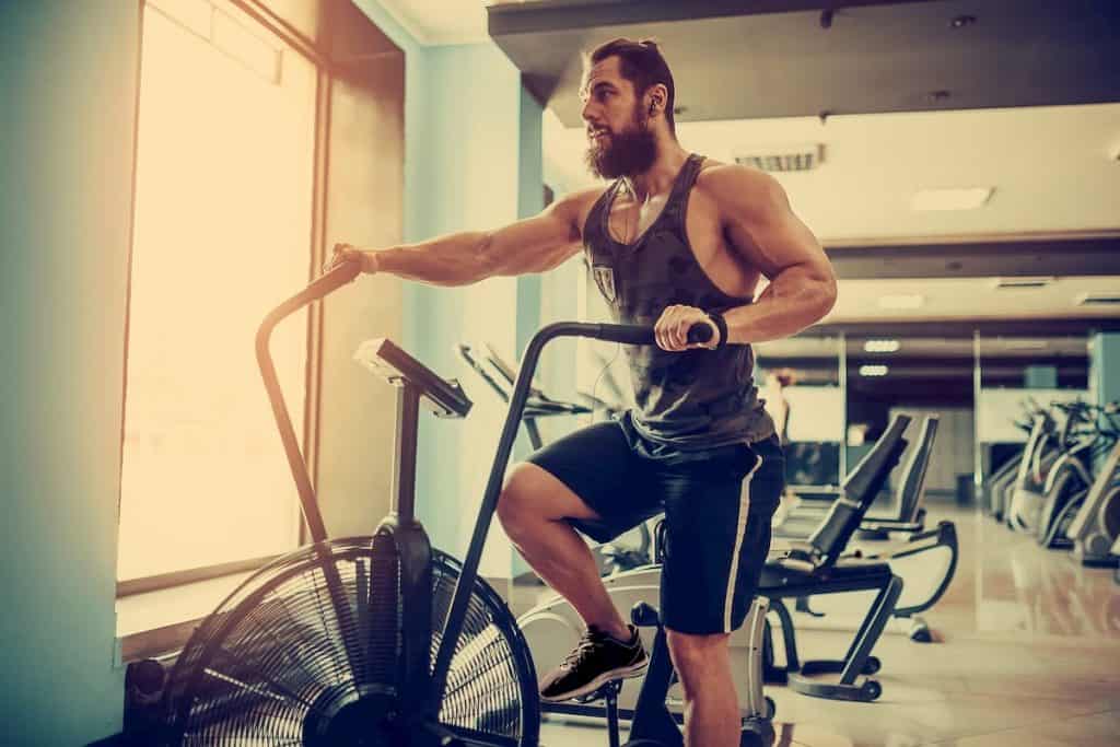 male using air bike for cardio workout at Functional training gym - Why is my Cardio Fitness Not Improving