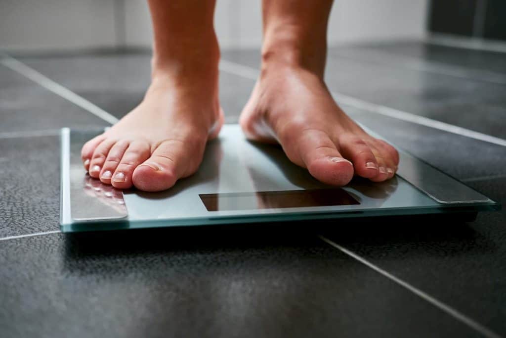 feet with weight scale in the bathroom - Do Calories Matter on Keto or Just Carbs