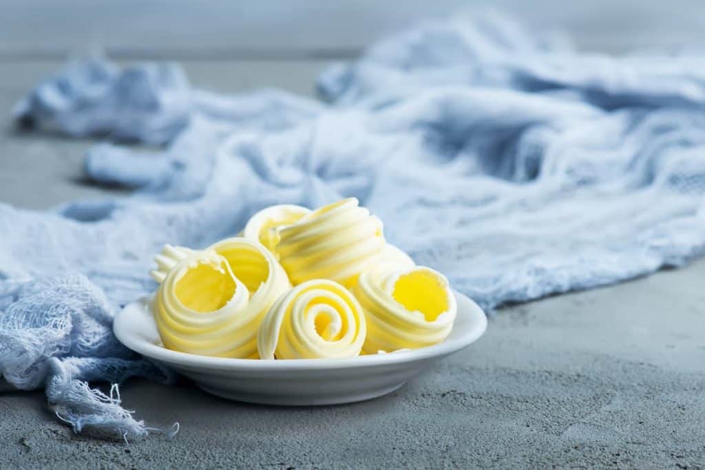Butter on plate and on a table - Is Too Much Butter Bad on Keto
