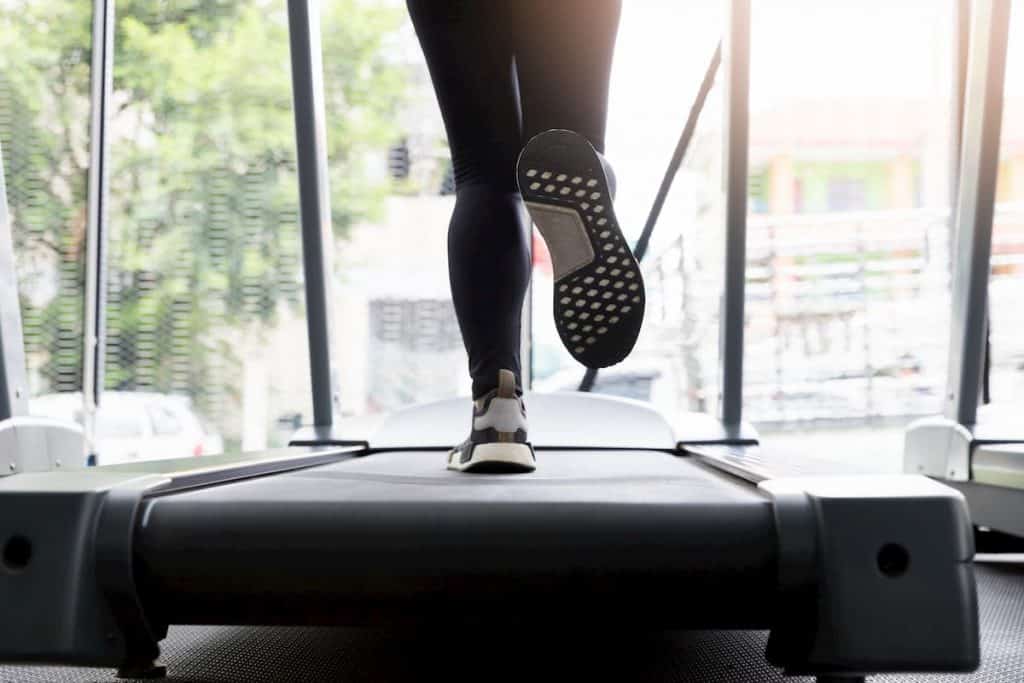Woman on a treadmill in a fitness club - What Workouts Burn the Most Fat