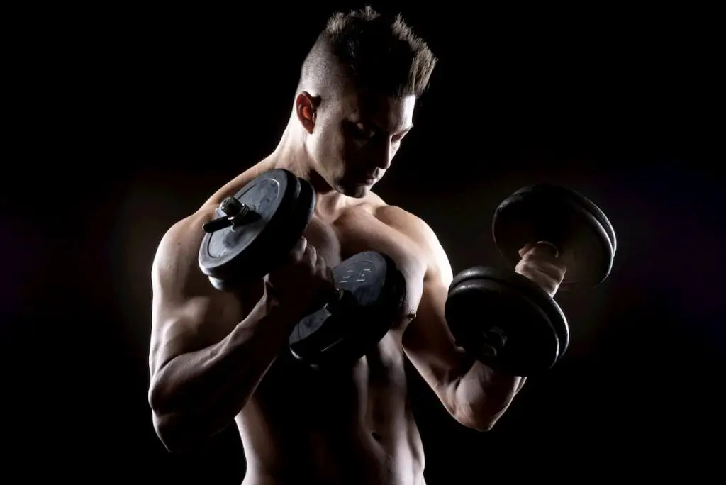 Muscular man weightlifting - is calisthenics better than weightlifting