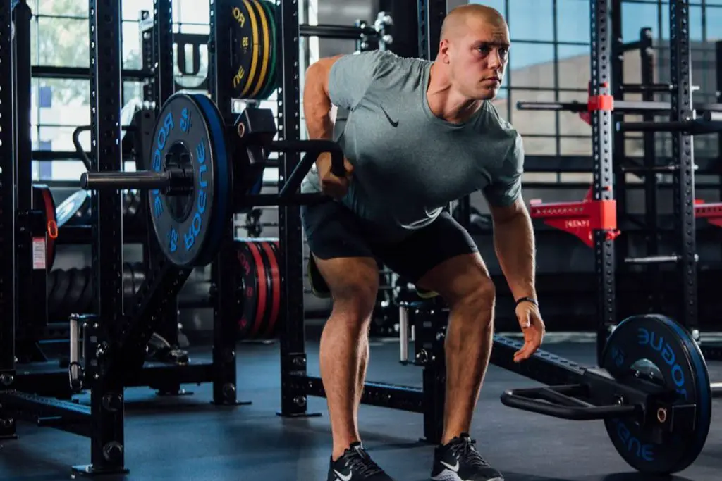 Man lifting on a Rogue Fitness rack getting his strength training in - What Workouts Burn the Most Fat