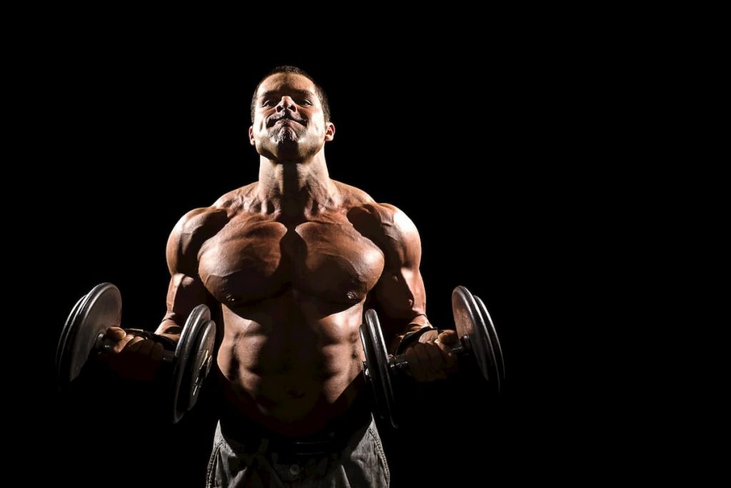 Strong male doing a bicep curl with weights - what does a dent in your bicep mean