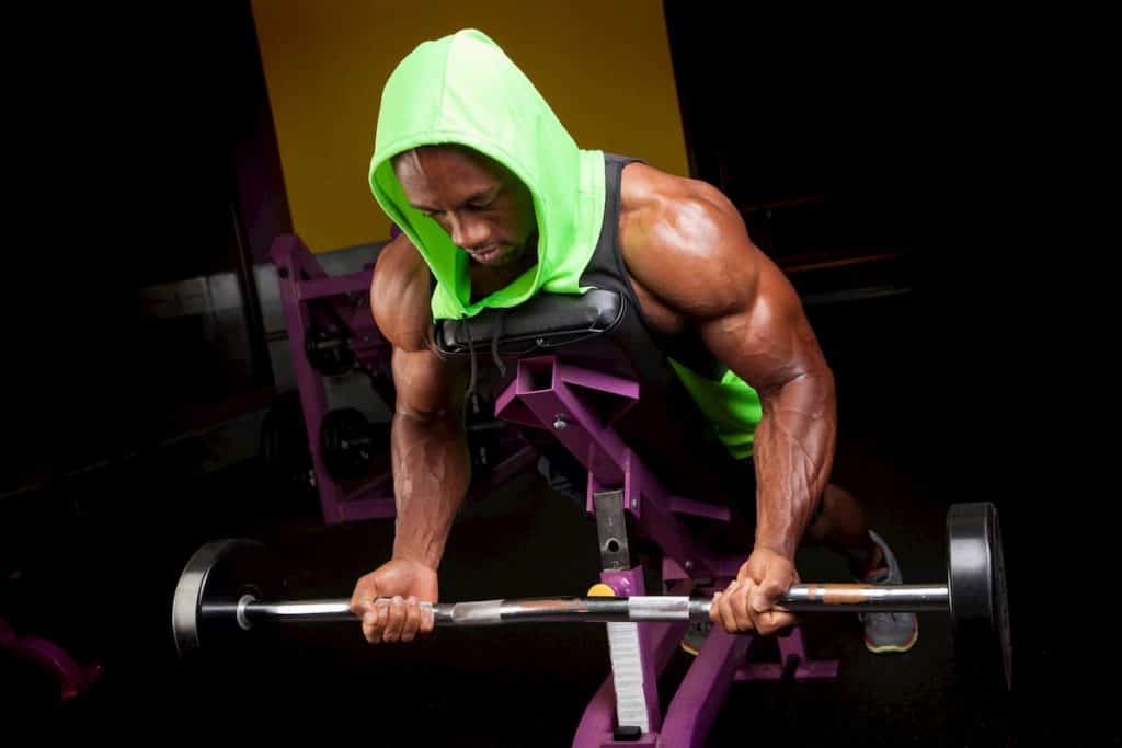 Toned and ripped man with lean muscle lifting weights on a curling bar - what does lean bulk mean