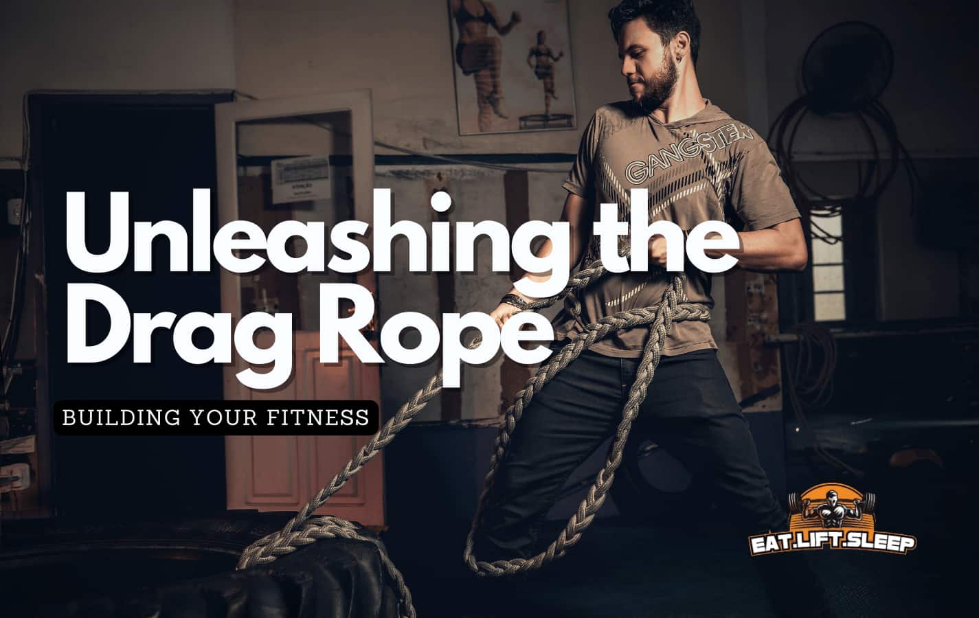 Man using a rope to drag a tire across the CrossFit gym floor